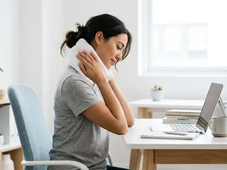 Person applying ice pack to neck as a pinched nerve cure home remedy